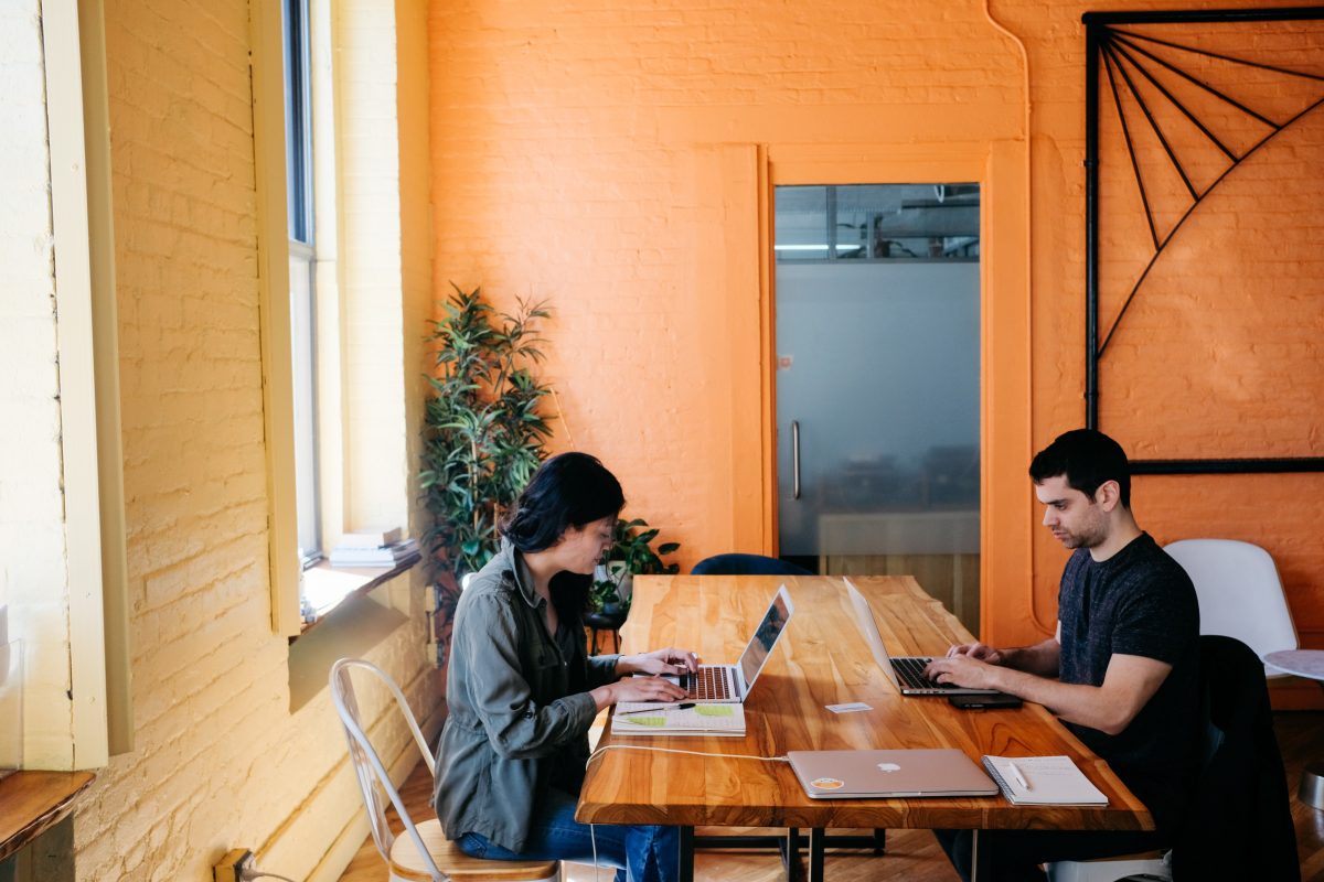 Communication in Remote Teams showing 2 people at a desk working